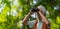 Senior man spending free time outdoors in nature, watching forest animals through binoculars.