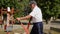 Senior man in sports pants and t-shirt stretching his legs and pumping muscles doing fitness exercises on iron outdoor