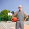 Senior man in sportswear holding a basketball