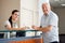 Senior Man Standing At Hospital Reception