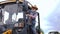 Senior man in straw hat entering cabin of huge tractor in slow motion. Portrait of confident professional Caucasian