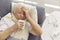 Senior man suffering from cold, flu or covid fever, coughing and having runny nose