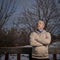 Senior man in a sweatshirt is starring at winter sky