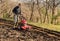 Senior man tilling ground soil with a rototiller in the garden.