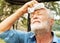 Senior man tired Wiping sweat with a towel in the park, health care concept