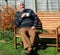 Senior man very relaxed with a coffee or tea outside.