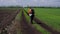 Senior man with walking stick walking on a dirty road