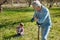 Senior man watching his grandson digging into soil