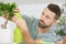 senior man watering bonsai leaves