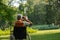 Senior man in wheechair spending free time outdoors in nature, watching forest animals through binoculars.