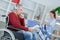 Senior man in wheelchair with help carer