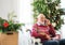 A senior man in wheelchair with mobile phone at home at Christmas time, making a phone call.