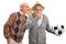 Senior man whispering to friend holding a deflated soccer ball and laughing