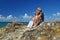 Senior man & woman sitting top of island cliff