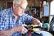 Senior Man Working On Model Radio Controlled Aieroplane In Shed At Home