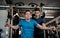 A senior man with a young trainer doing strength workout exercise in gym.