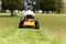 Senior man on zero turn lawn mower on turf