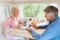 Senior married couple looking through family album with photos inside of camping vehicle