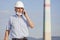 Senior or mature engineer, architect or inspector with face mask talking on mobile phone at a construction site or factory