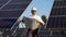 Senior mature engineer inspecting solar panels at power plant