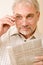 Senior mature man with glasses and newspaper