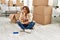 Senior middle east woman sitting on the floor at new home thinking looking tired and bored with depression problems with crossed