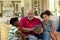 Senior mixed race man sitting on the couch with his young grandson and granddaughter