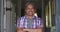 Senior mixed race man standing in open front doorway smiling