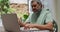 Senior mixed race man wearing lowered face mask having medical consultation using laptop