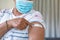 Senior mixed race woman in face mask showing plaster after vaccination