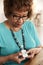 Senior mixed race woman pushing an assistance alarm which sheï¿½s wearing around her neck, close up