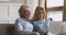 Senior mother and adult daughter using laptop looking at screen