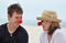 Senior mother & grown son in red noses laughing together