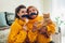 Senior mother and her adult daughter taking selfie with cat using photo booth props at home. Mother`s day concept