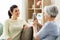 Senior mother photographing adult daughter at home