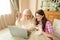 Senior mother together with her daughter waving at laptop camera.