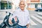 Senior motorcyclist man smiling happy holding moto helmet at the city