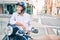 Senior motorcyclist man smiling happy wearing moto helmet at the city