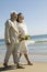 Senior newly weds walking arm in arm on beach