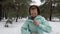 Senior old Caucasian woman  zips her jacket before running in the snowy winter park. Front shot