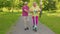 Senior old stylish tourists grandmother, grandfather using electric scooter while riding in park