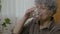 Senior old woman taking a pill swallowing and drinking a whole glass of water after it -
