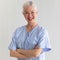 Senior older caucasian woman in hospital patient dress with positive smile face cross arms and looking to camera with strength