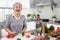 Senior or older woman with grey hair cooking in kitchen