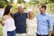 Senior Parents With Adult Children On Walk In Park