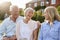 Senior Parents Sitting On Seat In Garden With Adult Daughter