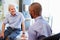 Senior Patient And Doctor Have Consultation In Hospital Room