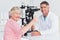 Senior patient gesturing thumbs up while sitting with optician