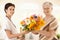 Senior patient giving flowers to nurse