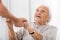 Senior Patient Holding Hands Of Female Doctor